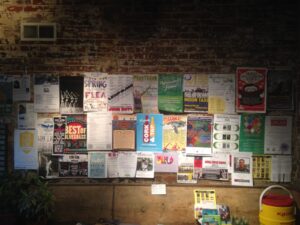 Bulletin board at 3rd Street Stuff Coffee Shop, crowded with posters touting current events