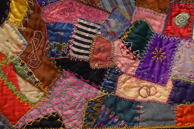 Image: Detail of Crazy Quilt, Anonymous, Undated, textile. An up close look at colorful patchwork with various patterns and shapes. Photo by Kim Kobersmith.