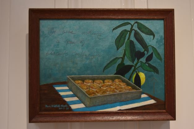 Image: Pam Oldfield Meade. "It Was Nothing a Pan of Biscuits Couldn’t Fix," 2017, mixed media, 9” x 12”. A painting of a pan of biscuits on a table with a plant and blue wall in the background. Photo by Kim Kobersmith.