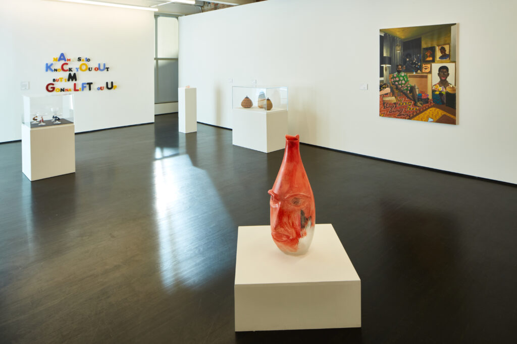 Image: Installation view of Crafting the Vernacular at KMAC Museum (courtesy of KMAC Museum). Various artworks that range from two-dimensional painting to three-dimensional sculpture are on view in a gallery with white walls. Photo by Ted Wathen.