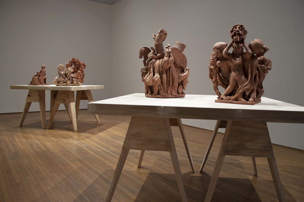 Image: An installation view of A Thought is a River, curated by John Knuth. Four brown sculptures by Hammerlein sit atop two tables in The Carnegie’s Hutsun Gallery. Photo by CM Turner.