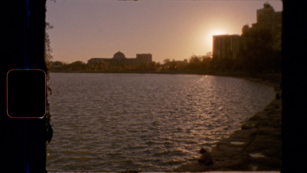 Image: Carlos Javier Ortiz, Poem To Benicio 3. A color photograph showing a body of water and a curved shoreline with building lining it. The sun is setting. Image courtesy of the artist.