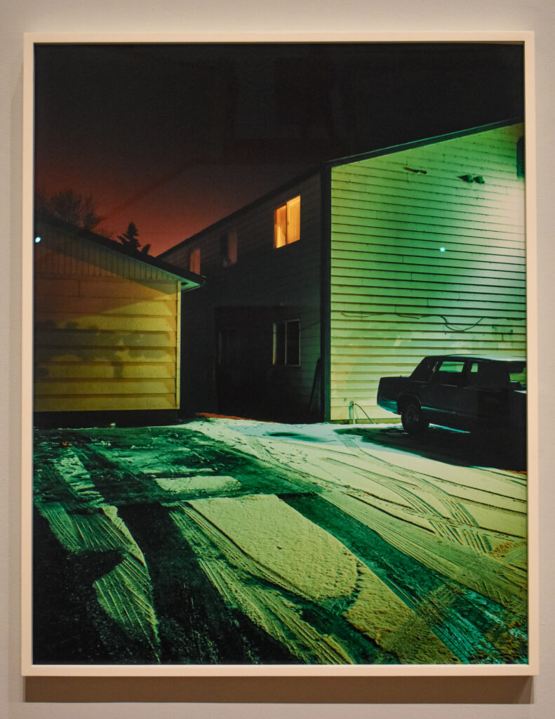 Image: Todd Hido, untitled image from Homes at Night series, pigment C-print. A house lit up with green light during a dark night. Photo by Kevin Nance.