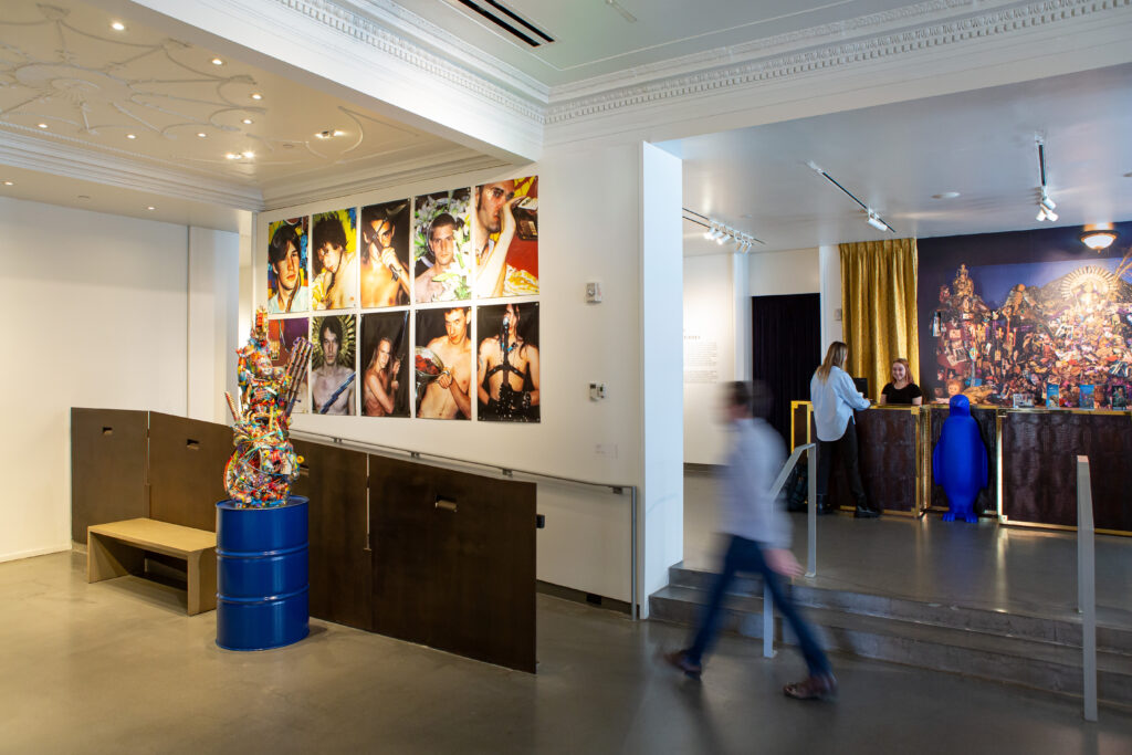 Image: Robert Morgan, Crab Nebula, 2013. Mixed Media AND YWM Banners, 1999-2000. Digital prints on vinyl banners. A view of Robert Morgan's exhibition at 21c Lexington. In the foreground on the left is a mixed-media sculpture by the artist and ten photographs. On the right in the background is a large digital reproduction of an altar-like, mixed media piece by the artist. Image courtesy of 21c Lexington.  